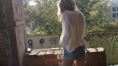 Terk edilmiş bir binada kalıntıları ile yürüyüş kamera poz kız modeli.