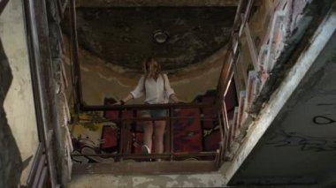 Terk edilmiş bir binada kalıntıları ile yürüyüş kamera poz kız modeli.