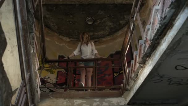 Flicka modell poserar på kameran vandra genom ruinerna av en övergiven byggnad. — Stockvideo