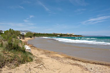 Rafina, Attica yakınlarındaki Marikes Sahili 'nin yaz manzarası, kumlu kıyılar ve berrak turkuaz suları, seyahat ve turizm için ideal huzurlu bir kıyı manzarası yaratıyor..