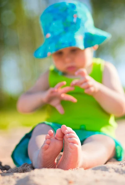 Niedliches Baby sitzt auf dem Sand — Stockfoto