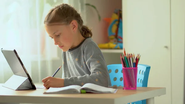 귀여운 아이들은 노트북을 교육, 온라인 공부, 가정 학습에 사용 합니다. 소녀는 멀리서 공부를 합니다. 가정 학습에 대한 개념 — 스톡 사진