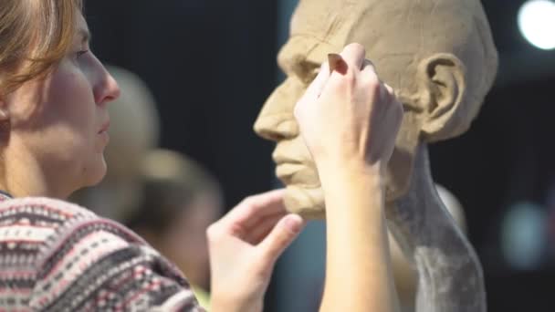 Bildhauerin bei der Arbeit an einer Skulptur eines menschlichen Kopfes. — Stockvideo