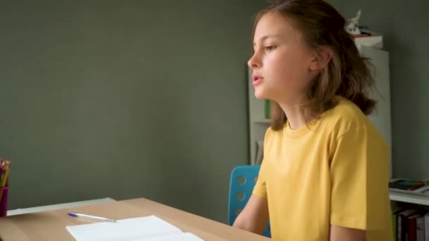 O portátil bonito do uso da criança para a instrução, estudo em linha, casa que estuda. Menina tem dever de casa na escola em casa. — Vídeo de Stock