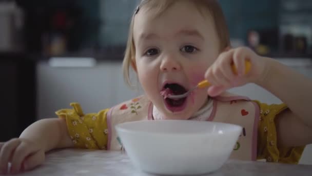 Roztomilé dětské jídlo. Dítě dívka jíst zdravé jídlo sama. — Stock video