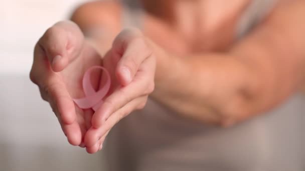 Kadın pembe kurdele tutuyor. Ekim ayında el görüşünü ulusal göğüs kanseri farkındalığı ayının sembolüyle kapat — Stok video