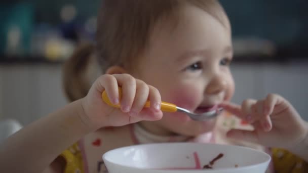 Lindo niño comiendo. Bebé niña comiendo comida saludable ella misma. — Vídeos de Stock