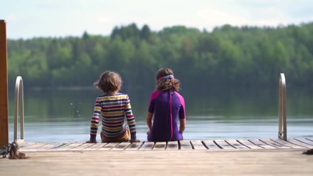 Девочка и мальчик, сидящие на деревянном пиале у лакея. — стоковое видео