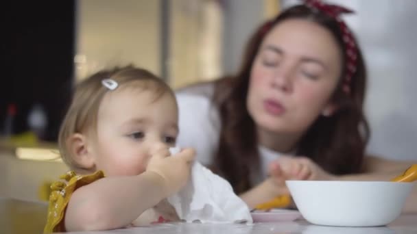 Roztomilé dětské jídlo. Holčička sama jí zdravé jídlo. Máma krmí svou dcerku — Stock video