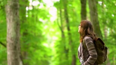 Sırt çantalı bir kadın ormanda yolda tek başına yürüyor. Seyahat yaşam tarzı konsept macera açık hava yaz tatilleri