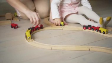 Anne ve kızı evde oyuncaklarla oynuyorlar. Anne küçük kızına yardım ediyor. Aile yaşam tarzı konsepti