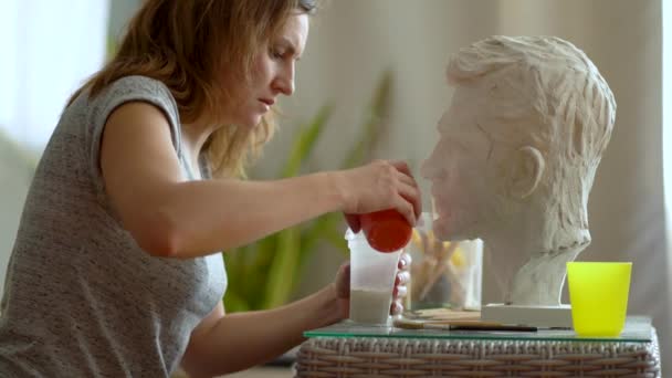 Pematung memperbaiki patung gipsum kepala manusia. Wanita yang bekerja di studio. Pencetakan plester dan restorasi — Stok Video