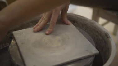 Seramik üretimi. Çömlek çarkında çamurla çalışan kadın..