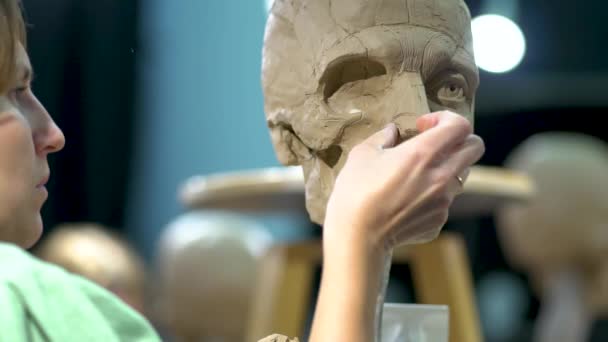 Pematung menciptakan patung kepala manusia. Wanita yang bekerja di studio. Anatomi konstruksi hidung — Stok Video