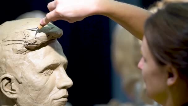 Kvinnlig skulptör på jobbet. Skulptur av ett mänskligt huvud. — Stockvideo