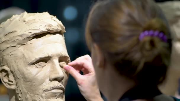 Mujer escultora trabajando en una escultura de una cabeza humana. — Vídeos de Stock