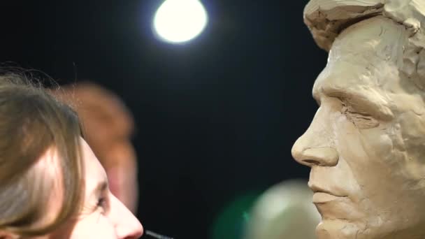 Mujer escultora trabajando en una escultura de una cabeza humana. — Vídeos de Stock