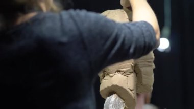 Kadın heykeltraş, insan kafası heykeli üzerinde çalışıyor..