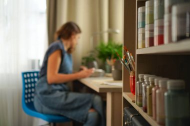 Kadın atölyede seramik ve çömlek takımı yapıyor. Çamurdan çömlek yapan kız