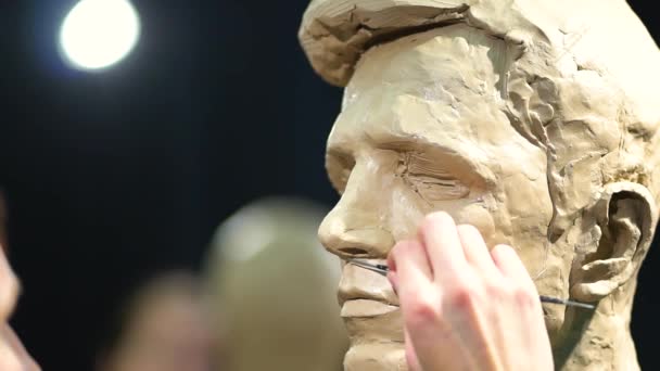 Mujer escultora trabajando en una escultura de una cabeza humana. — Vídeos de Stock