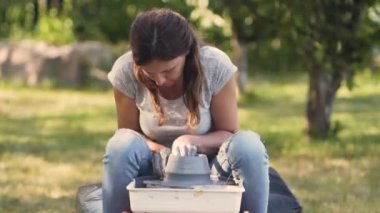 Seramik üretimi. Çömlek çarkında çamurla çalışan kadın..