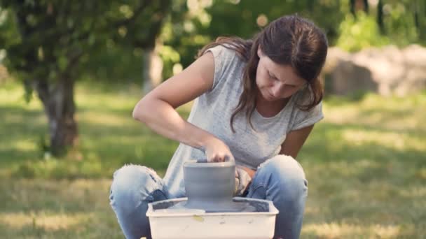 The manufacture of ceramics. Woman working with clay on pottery wheel. — Stock Video