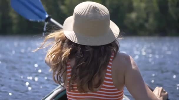 Beautiful young woman kayaking on lake. Girl rowing oars on a kayak on the river. Sports hike, water rafting in nature — Stock Video