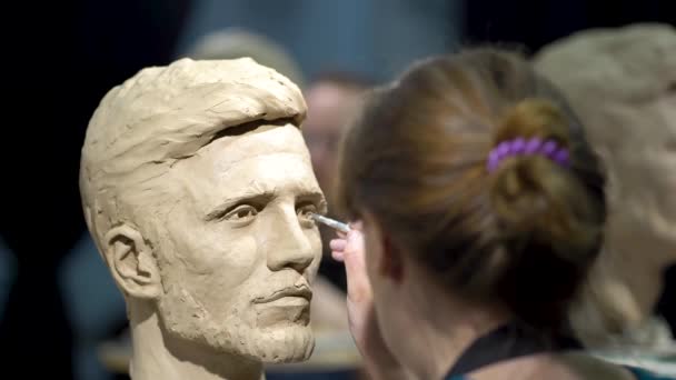 Mujer escultora trabajando en una escultura de una cabeza humana. — Vídeos de Stock