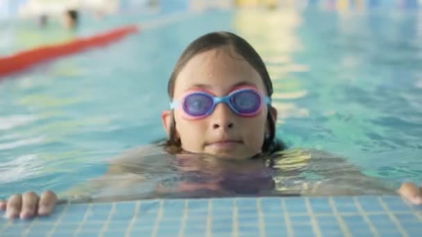 Glada barn i poolen. Sport livsstil koncept. Pojke och flicka på simlektioner — Stockvideo