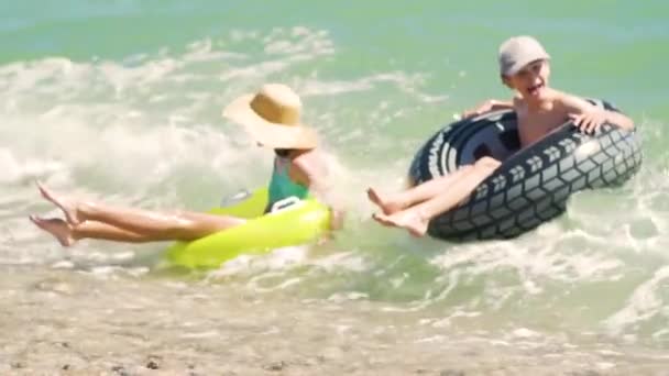 바다에서 수영하는 행복 한 아이들. 여름 방학. 부풀릴 수있는 반지를 끼고 있는 소년 과 소년 은파 도를 타고 간다. 아이들은 휴가를 즐기죠 — 비디오