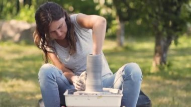 Seramik üretimi. Çömlek çarkında çamurla çalışan kadın..