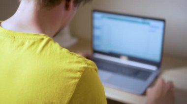 Adamın biri dizüstü bilgisayarını bir projede uzak mesafe çalışması için kullanıyor. Ev kavramından çalış