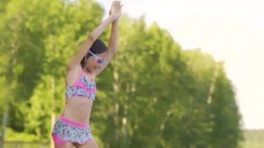 Tahta iskeleden göle atlayan dalgıç kıyafetli kız. Yaz günü eğleniyorum..