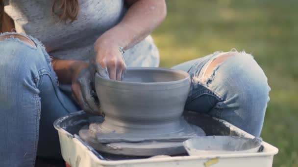 Виготовлення кераміки. Жінка, що працює з глиною на керамічному колесі. Потягніть форму пластини. Крупним планом вид рук — стокове відео