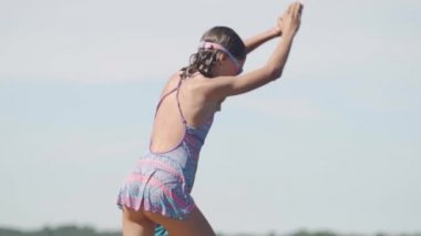 Dalgıç kıyafetli kız ve oğlan tahta iskeleden göle atlıyorlar. Yaz günü eğleniyorum..