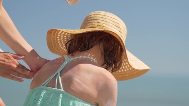 Mãe aplicando creme protetor solar no ombro de suas filhas. Proteção solar de pele de crianças. — Vídeo de Stock