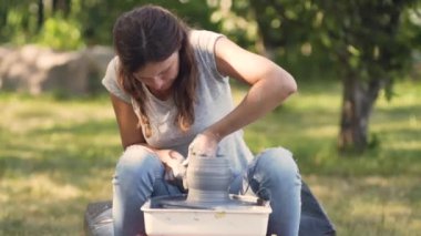 Seramik üretimi. Çömlek çarkında çamurla çalışan kadın..