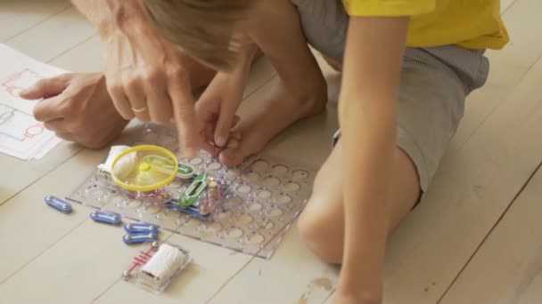 Mio padre gioca con mio figlio. La famiglia passa del tempo insieme. Lezioni di robotica a casa con i genitori. — Video Stock