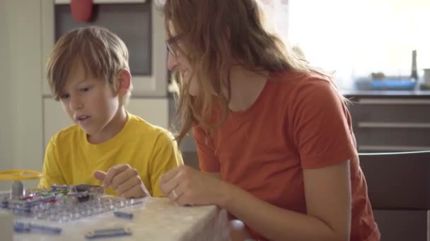 Mutter spielt mit Sohn. Die Familie verbringt Zeit miteinander. Robotikkurse zu Hause bei den Eltern. — Stockvideo
