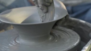 Seramik üretimi. Çömlek çarkında çamurla çalışan bir kadın. Plakanın şeklini alıyorum. Ellerin görüntüsünü kapat