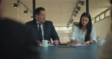 İki iş adamı firmanın toplantı odasında müşterileriyle görüşüyor. Orta çekim, yavaş çekim..