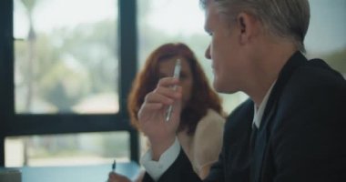 İki iş adamı bir toplantıda ortaklarıyla proje planlamasını tartışıyor. Yaklaşın, ağır çekim..