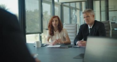 Bir grup iş ortağı bir proje stratejisini tartışıyor. Orta çekim, yavaş çekim..