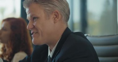 Toplantı sırasında ekibin geri kalanıyla proje stratejisini tartışan bir iş adamının yakınlaşması. Yavaş çekim.