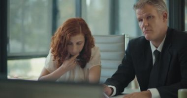 Ofis odasında bir iş görüşmesi sırasında not alan iki kişinin orta ölçekli görüntüsü. Yavaş çekim.