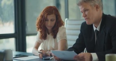 Pazarlama toplantısı sırasında iş arkadaşlarına telefonunda yeni bir eklenti gösteren bir iş kadını. Yavaş çekim.