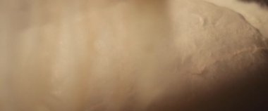 Taze pizza hamurunun üzerine beyaz un yayılıyor. Yaklaşın, ağır çekim..