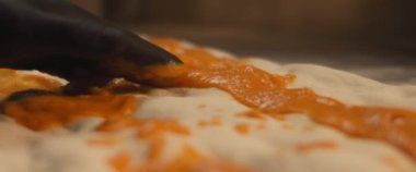 Şef taze pizza al taglio hamuruna özel kabak sosu sürüyor. Yaklaşın, ağır çekim..