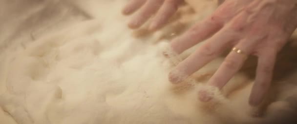 Şef elleriyle geleneksel pizza hamuru hazırlıyor, yavaşça hamur yoğuruyor. Yaklaşın, ağır çekim. — Stok video