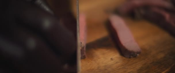 Chef snijdt medium rare vlees staak met mes. Close up, slow motion. — Stockvideo